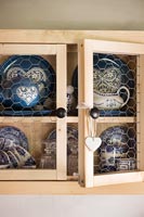 Blue and white crockery in small wooden wall unit 