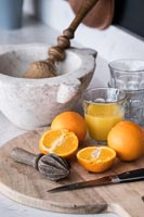 Fresh oranges and juice on kitchen worktop 
