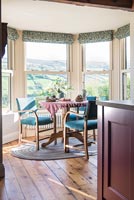 Table and chairs by window in dining room with countryside views 