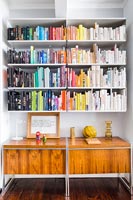 Modern wooden sideboard under wall mounted bookshelves 
