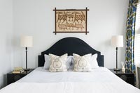 Modern bedroom - artwork above black and white bed 