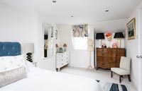 Wooden chest of drawers in white bedroom 