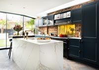 Modern kitchen with black units and a white marble island