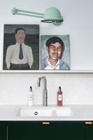 Paintings on shelf above modern kitchen sink 