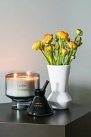Flowers on side table next to candle 
