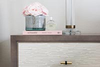 Pink flowers and accessories on modern sideboard 