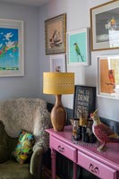 Pink painted sideboard and colourful pictures