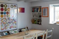 Colourful modern artwork on wall of small country dining room 