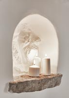 Candles in white wall alcove with stone shelf