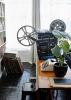 Retro typewriter and film projector on table