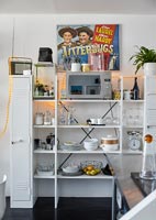 Kitchen storage shelves for crockery and microwave with retro ornaments and wall art