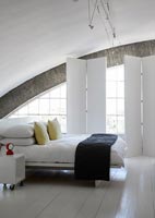 Arched window in bedroom with painted wooden floor