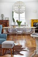Clear plastic dining chairs around table in modern open plan living space 