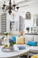Blue accessories in white shabby chic style living room 