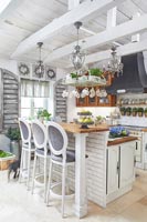 Bar stools and breakfast bar in small country style kitchen
