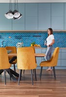 Brightly coloured open plan apartment with middle eastern influence with woman in kitchen area
