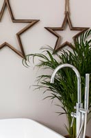 Wooden star ornaments on wall behind bath 