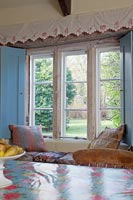 Country dining room with window seat overlooking garden 