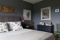 Modern bedroom with grey painted walls and vintage furniture items 
