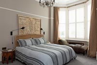 Striped bedding in modern bedroom with period details 