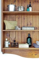 Toiletries and accessories on wooden bathroom shelves - detail 