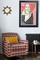 Patterned armchair and large poster in modern living room 