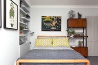 Yellow and grey bedding and vintage furniture in modern bedroom 