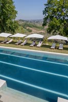 Swimming pool with loungers and scenic views of landscape beyond 