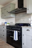 Large black range cooker and extractor fan in modern kitchen 