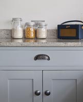 Food jars and vintage radio on kitchen worktop 