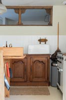 Butler sink on wooden cabinet in simple country kitchen 