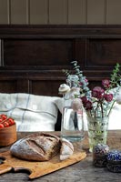Fresh bread displayed on dining table with vase of flowers