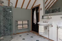 Country bathroom with enclosed shower and twin sinks