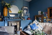 Living room with mirror on mantlepiece and painted alcove cupboards