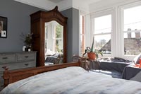 Vintage wooden furniture in grey bedroom