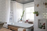 Roll top bath with white metro brick tiling