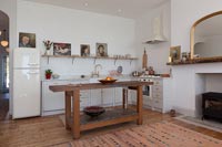 Simple wooden island in white modern kitchen with retro appliances 