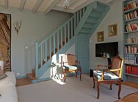 Blue painted staircase and matching bookcase in country living room 