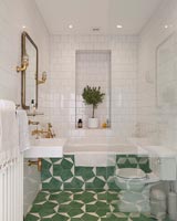 Green and white patterned tiling on floor of modern bathroom 