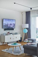 Wall mounted television above sideboard in modern living room 