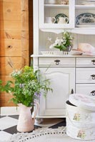 White wooden dresser with flowers and floral hat box