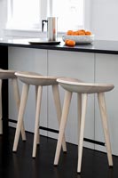 Modern kitchen island with stripped wooden barstools next to island