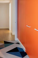 Bright orange painted wardrobe doors and patterned carpet