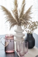 Detail of dried grasses in vases on modern dining table