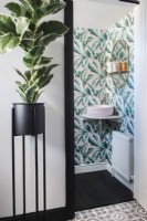 View into modern bathroom with patterned wallpaper 
