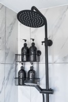 Detail of black shower head and grey marble tiles in modern bathroom