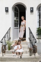 Family portrait in front of an outdoor entrance with classic stair and door