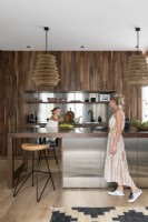 Family in an open-plan modern kitchen with built-in cabinet in wood and stainless steel