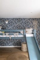 Childrens room with wallpaper and bunkbed with slide