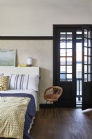 Country bedroom with open black framed door 